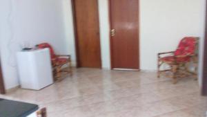 a living room with two chairs and a refrigerator at suítes economy uberlandia in Uberlândia +12 photos