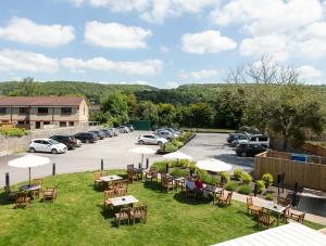 un patio con tavoli e sedie in un parcheggio di The Bath Arms Hotel a Cheddar