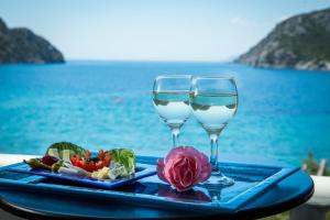 a tray with two glasses of wine and a plate of food at Hotel Porto Koufo in Porto Koufo