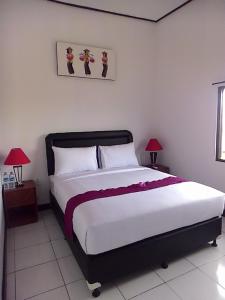 um quarto com uma cama grande e 2 candeeiros em Sari Room Bed & Breakfast em Nusa Dua