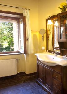 ein Bad mit einem Waschbecken, einem Spiegel und einem Fenster in der Unterkunft Agriturismo Sant'illuminato in Calzolaro