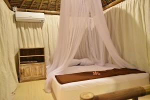 Bett mit Baldachin in einem Zimmer in der Unterkunft Salty Shakas Bamboo Stay Canggu in Canggu