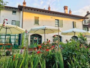 a building with umbrellas and flowers in front of it at B&B La Borasca - Rooms in Casalpusterlengo
