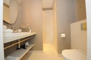 La salle de bains est pourvue d'un lavabo, de toilettes et d'un miroir. dans l'établissement Designhotel Rosenbohm, à Oldenbourg
