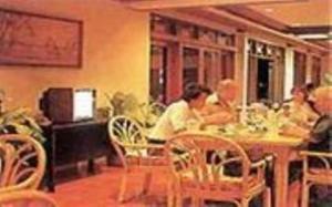 um grupo de pessoas sentadas numa mesa num restaurante em Hotel Sahid Toraja em Makale