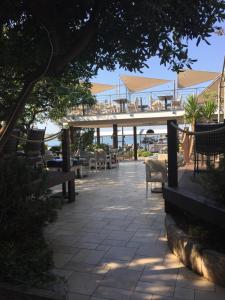 a patio with chairs and tables and a deck at Guesthouse Punta Mira - Beachfront in Novalja