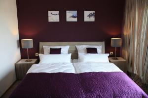 a bedroom with a large bed with purple sheets and pillows at Haus am Kipp in Gutenacker