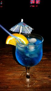 a blue drink with a lemon and an umbrella at Recreation Complex Uzhanski Kupeli in Volosyanka