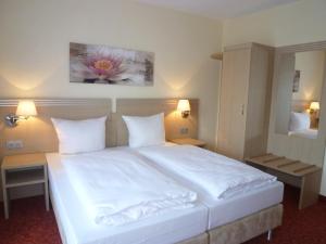 a bedroom with a large white bed with two lamps at Gästehaus Deidesheim in Deidesheim