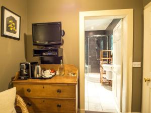 a room with a dresser with a television on top of it at Six Brunton Place Guest House in Edinburgh