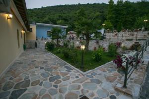 cortile con passerella in pietra accanto a un edificio di Neromylos a Nikísiani