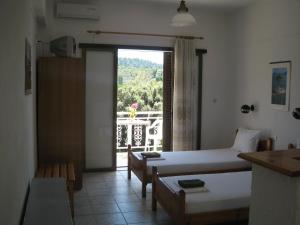 1 dormitorio con cama y vistas a un balcón en Bellina Studios, en Agia Paraskevi