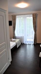 sypialnia z łóżkiem i dużym oknem w obiekcie Willa Różana - Apartamenty i Pokoje Gościnne w mieście Sandomierz