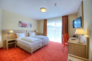 a hotel room with a bed and a desk at Gästehaus Deidesheim in Deidesheim