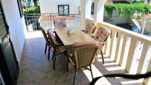 a wooden table and chairs on a balcony at Apartments Anamarija in Makarska