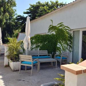 a patio with a table and an umbrella and chairs at A Teppa in Luri