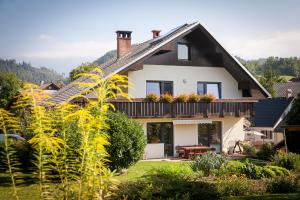 a house with a balcony with flowers on it at Apartma Slivnik in Spodnje Gorje