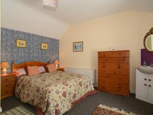 1 dormitorio con 1 cama, vestidor y lavamanos en Kerrigan's Cottage, en Commeen
