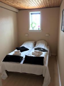 スケーエンにあるSkagen Villa & Apartmentsのベッドルーム1室(白いベッド1台、黒い枕付)