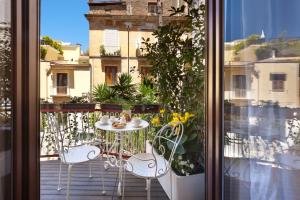 d'une terrasse avec une table et des chaises sur un balcon. dans l'établissement Sorrento Flower Rooms, à Sorrente