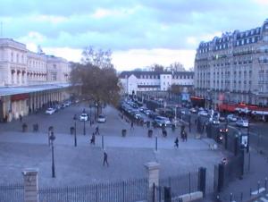 a crowd of people walking around a city with cars at Hôtel de Lorraine in Paris