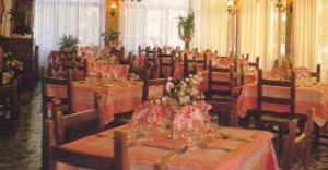 a dining room with tables and chairs with flowers on them at Albergo San Cristoforo in Pergine Valsugana