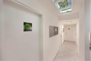 a hallway with white walls and a skylight at Sorrento Flower Rooms in Sorrento