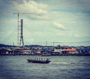 a boat in the water in front of a city at Kunyit 7 Lodge in Bandar Seri Begawan