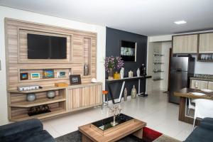 a living room with a television on a wall at Executivo Flat II in Parauapebas