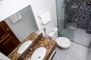 a bathroom with a sink and a toilet at Executivo Flat II in Parauapebas +7 photos