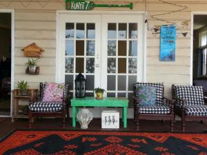 a porch with a green table and four chairs at Kunyit 7 Lodge in Bandar Seri Begawan