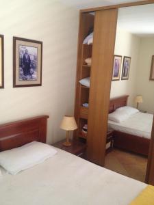 1 dormitorio con 2 camas y estante para libros en Apartments Kora - Herceg Novi Center, en Herceg-Novi