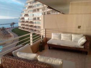 a balcony with a couch and chairs on a building at San Alfonso del Mar Ed Crucero in Algarrobo