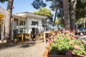 een restaurant met tafels en bloemen voor de deur bij Hostal Alcina in Cala Ratjada