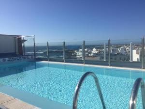 a swimming pool with a view of the ocean at Oliastur Cotillo Apartament in Cotillo