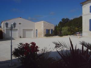 una casa blanca con luz de la calle en un aparcamiento en L'Oasis, en Port-dʼEnvaux