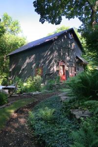 an old barn with a red door in front of it at 1795 Acorn Inn Bed and Breakfast in Canandaigua