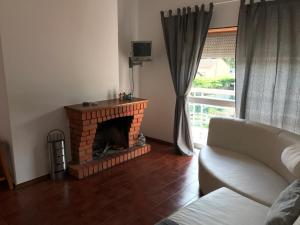 a living room with a brick fireplace and a couch at Europa Apart in Castanheira de Pêra