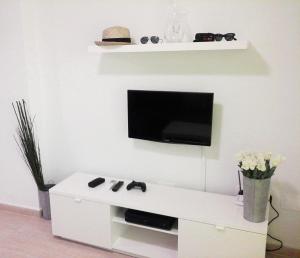 a white entertainment center with a tv on a wall at Apartament Sofia in Mar de Cristal