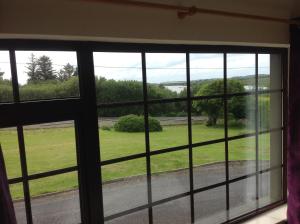 a window with a view of a green field at Auntie B's in Ardara