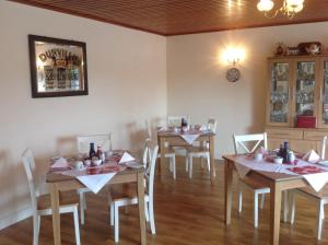 une salle à manger avec deux tables et des chaises blanches dans l'établissement Auntie B's, à Ardara