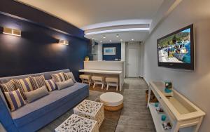 sala de estar con sofá azul y mesa en Aiolis Studios, en Porto Koufo