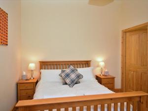 a bedroom with a bed with two night stands and two lamps at The White Lady in Worstead