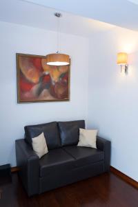 a black couch in a living room with a painting at Hotel Drim in Struga