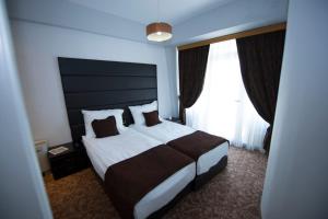 a bedroom with a large bed and a large window at Hotel Drim in Struga