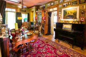 a living room with a table and a piano at Russell Manor Bed & Breakfast in Morrisburg