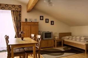 a living room with a bed and a table and a tv at Haus Lowe in Filzmoos