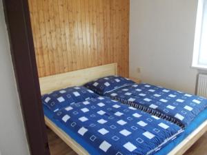 Bett mit blauen und weißen Kissen in einem Zimmer in der Unterkunft U dědy Jarka in Rožnov pod Radhoštěm