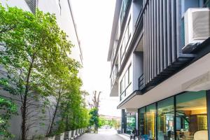a street between two buildings with trees at Jira Boutique Residence in Chiang Mai
