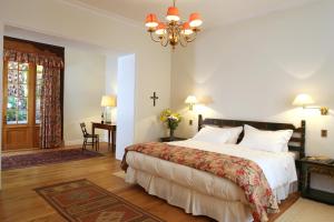 
a bedroom with a large bed and a large window at Hotel Casa Real - Viña Santa Rita in Santiago
